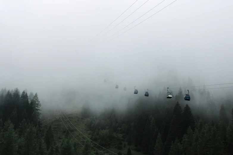 a group of ski lift suspended above the trees