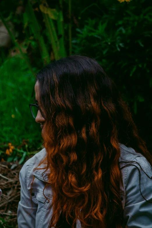 a woman is holding a cat and has long curly hair