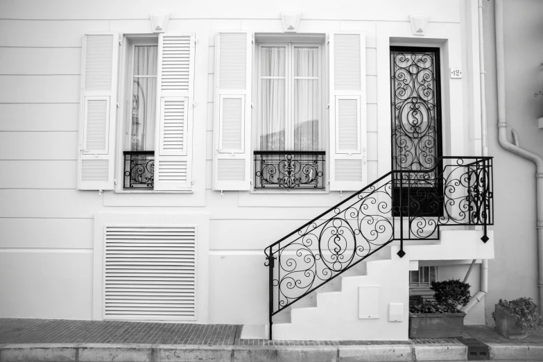 a staircase with windows on two sides, and some white shutters