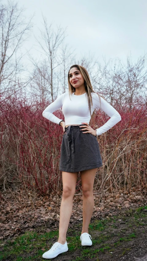 a woman in a white top standing outside