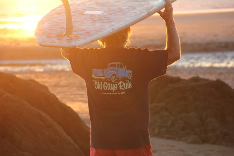 the man is holding his surf board near the beach