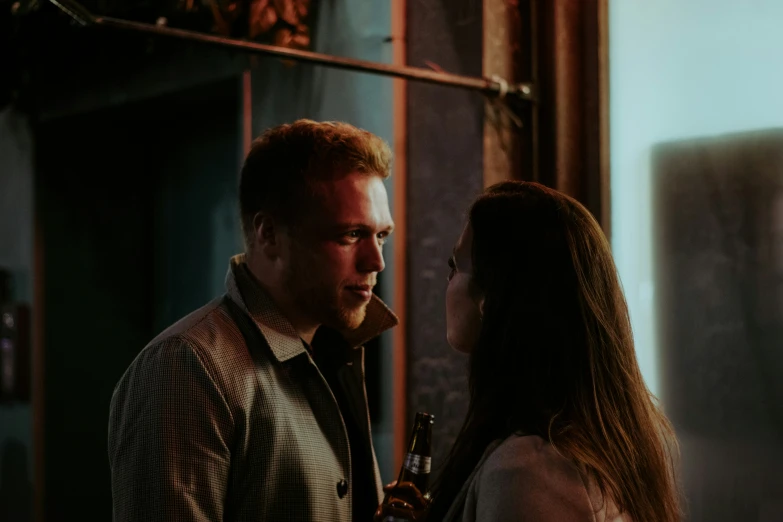 a man and woman are talking next to a window