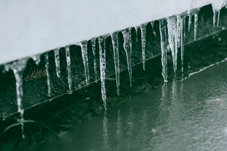 ice is growing up on the wall and next to the gutter