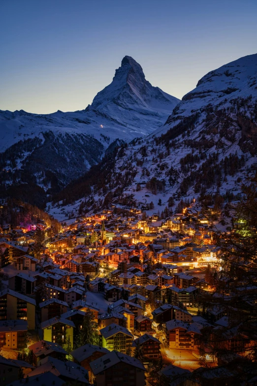 some buildings are lit up with lights on their faces in the evening