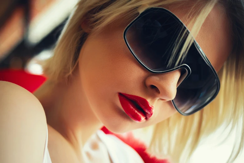 a woman wearing sunglasses and red lipstick poses for the camera