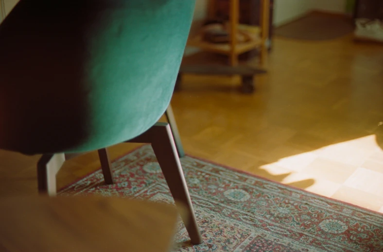 a green chair sitting on a hardwood floor