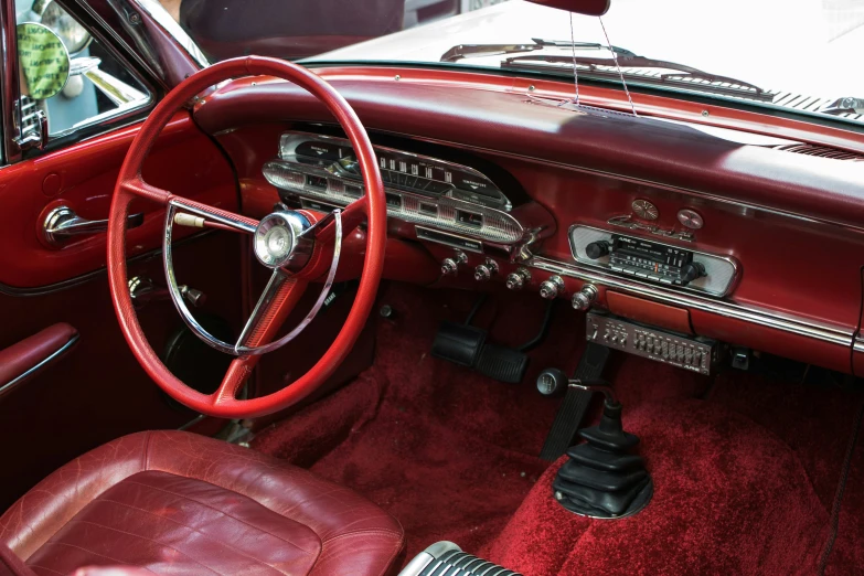 the interior of a red car with a steering wheel