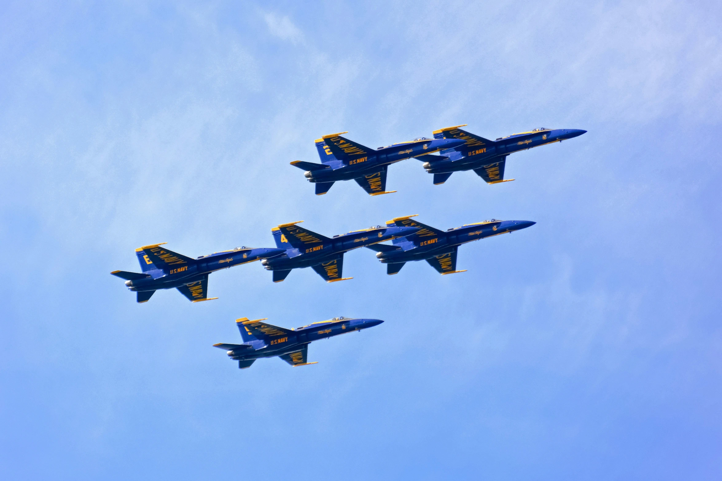 four fighter jets fly in formation in the sky