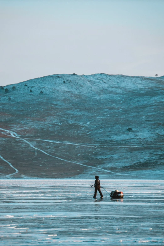 a man standing on the ocean near a small boat