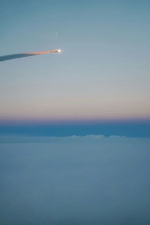 an airplane flying low over water at dusk