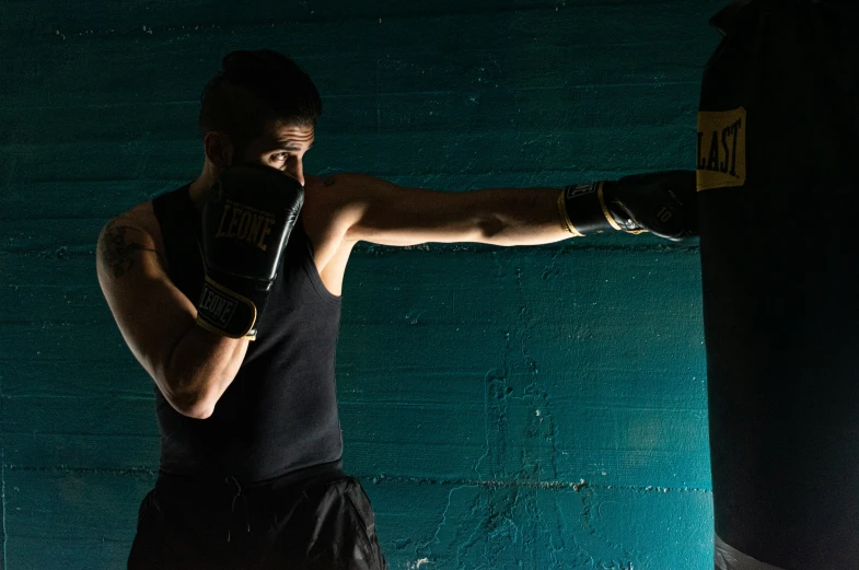 there is a man that is wearing gloves and punching his leg