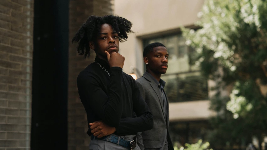 two young men are standing together and posing