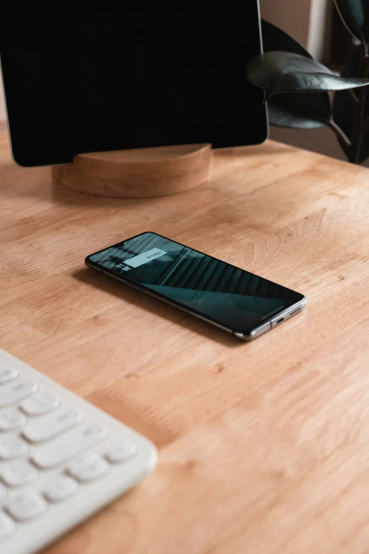 an iphone that is on a desk next to a keyboard