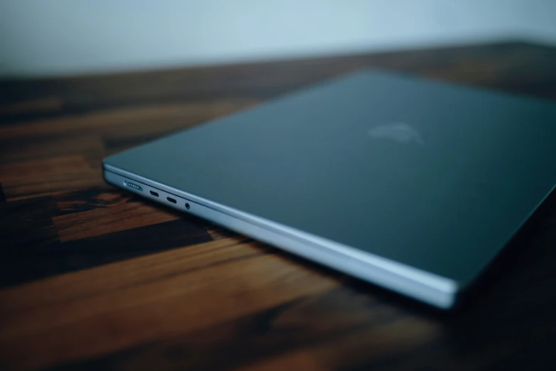 a black apple laptop sitting on top of a wooden table