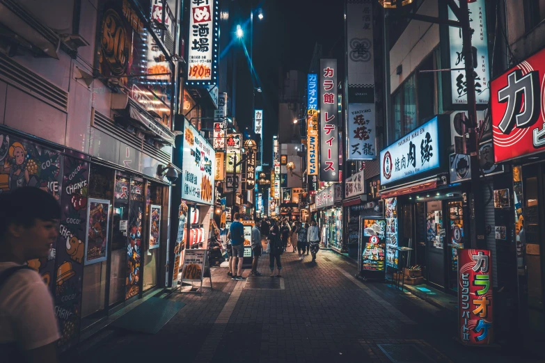 a city street is lit up with neon signs