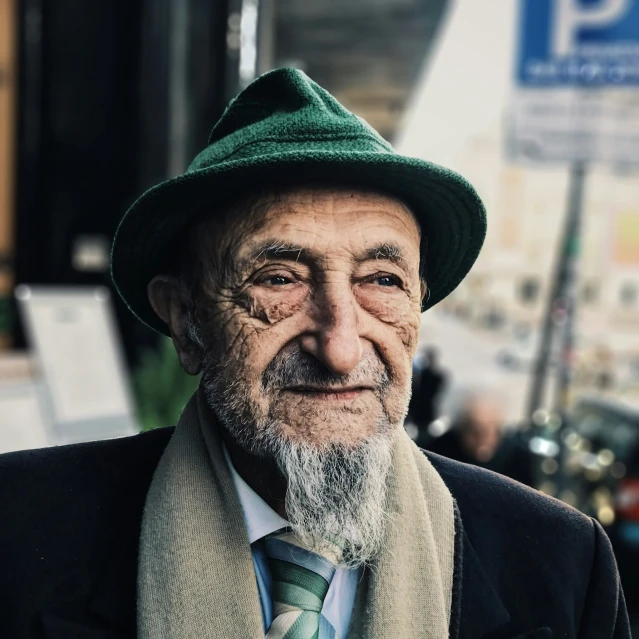 an elderly man wearing a green hat and jacket