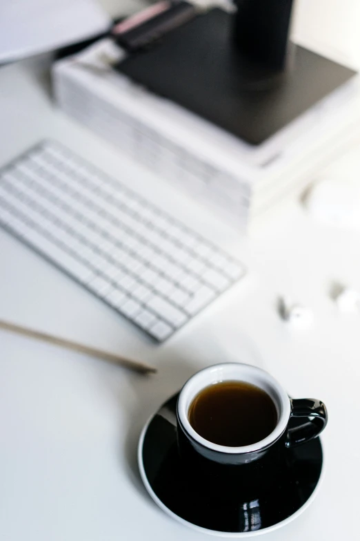 a cup of coffee sitting on top of a white desk