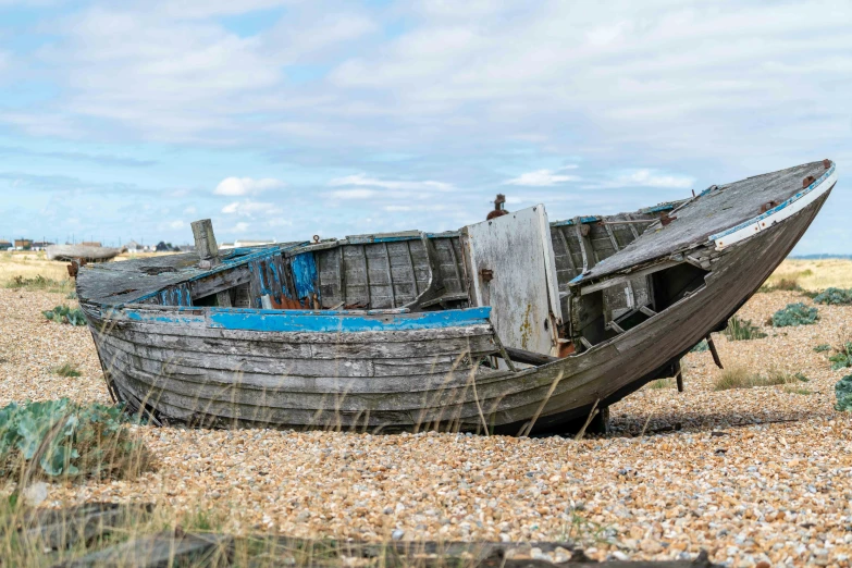 an old wooden boat laying in the sand