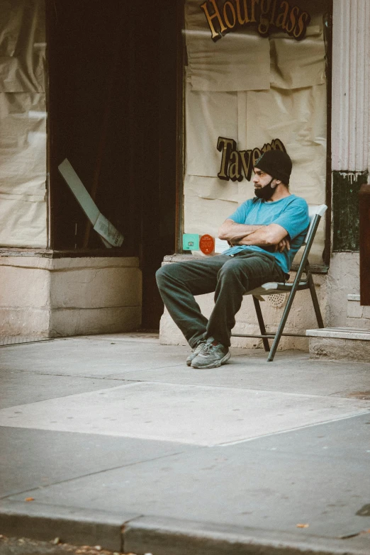 a man sitting in a chair next to a building