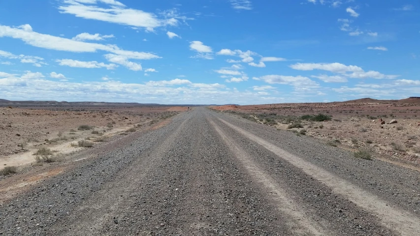 there is a motorcycle that is parked on the dirt road