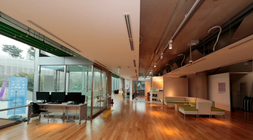 an empty, modern room with hardwood floors and a large window