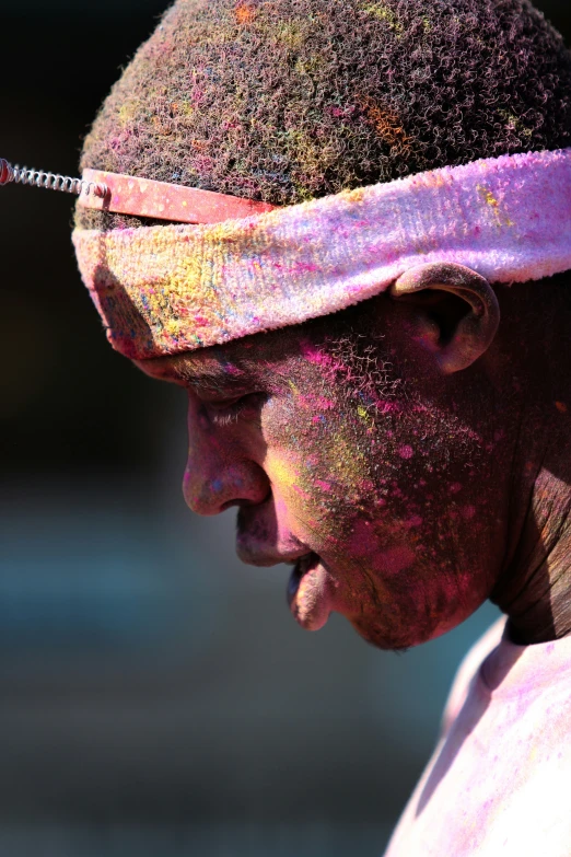 a man with purple face paint and head band