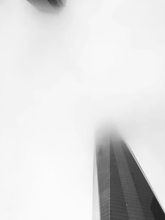 a very tall building under a sky with clouds