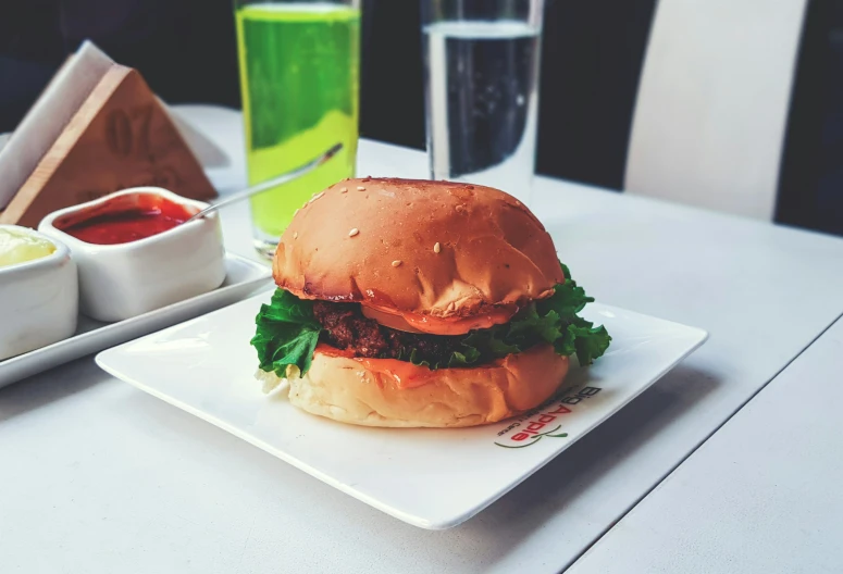 a sandwich and dip sit on a white plate