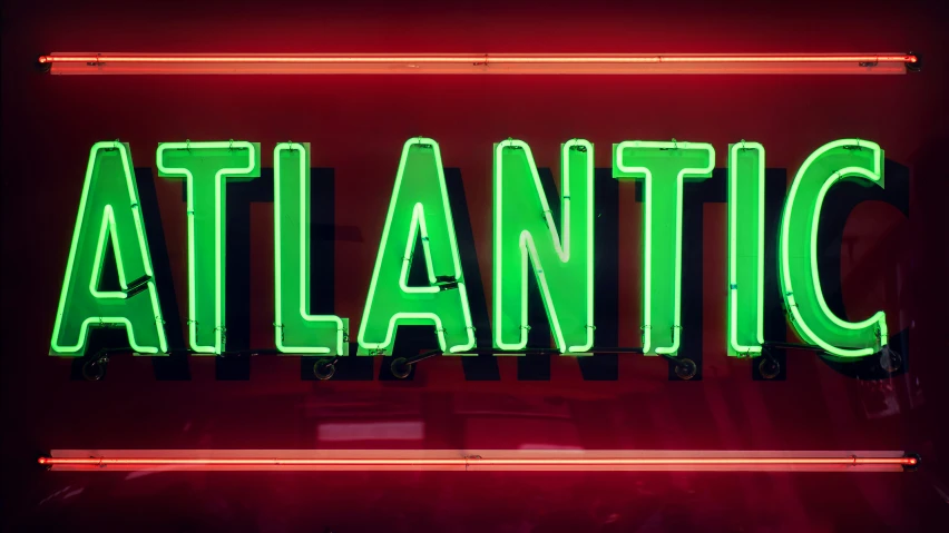 neon sign with the word atlantic hanging from a red wall