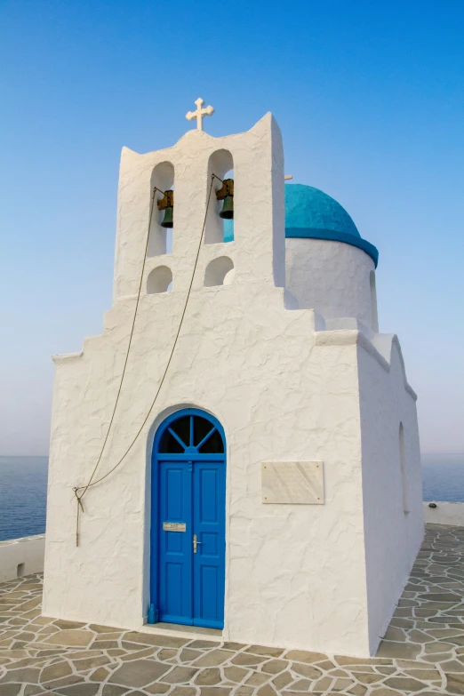 a large white building with blue doors and a cross