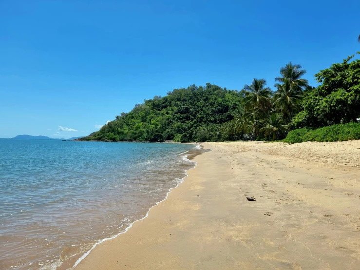 a blue sky and clear water on an idyllic beach