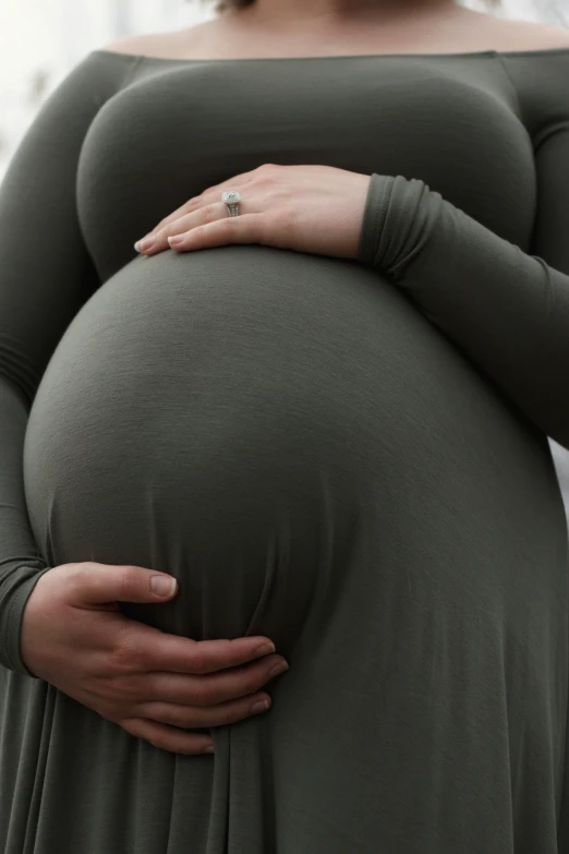 pregnant woman in long green gown, with belly wrapped around her