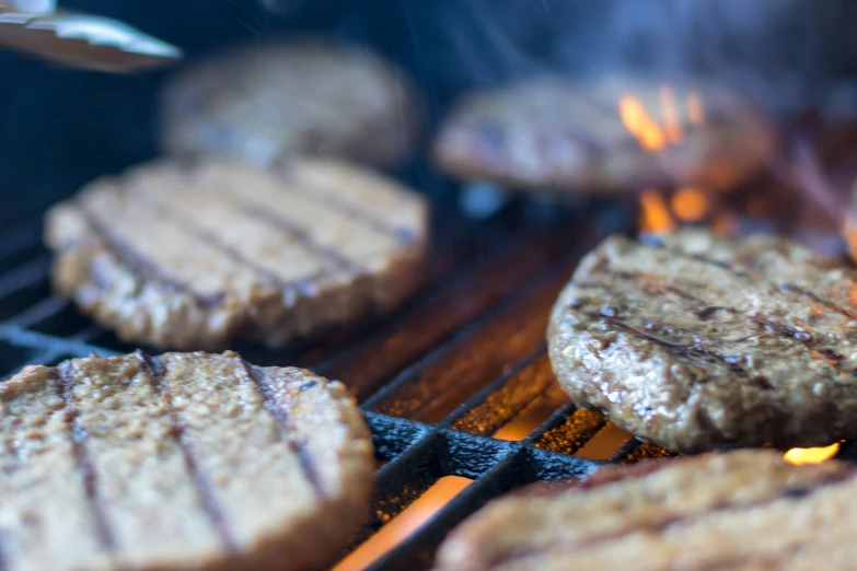 hamburgers and burger patties cooking on the grill