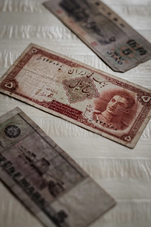two money bills lie on the bed with white sheets
