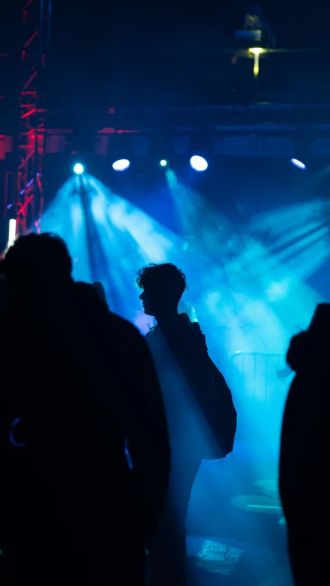 silhouetted people standing at an event in the dark