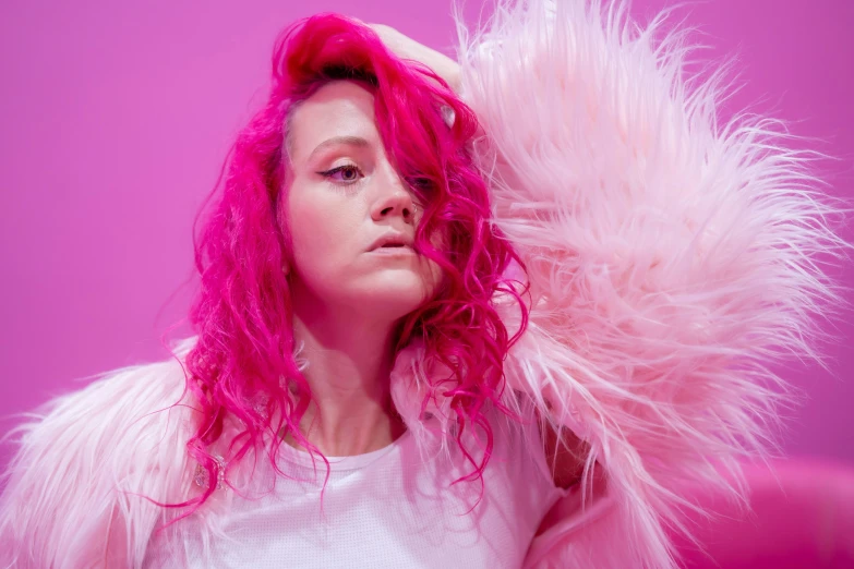 a woman wearing pink and white with pink hair