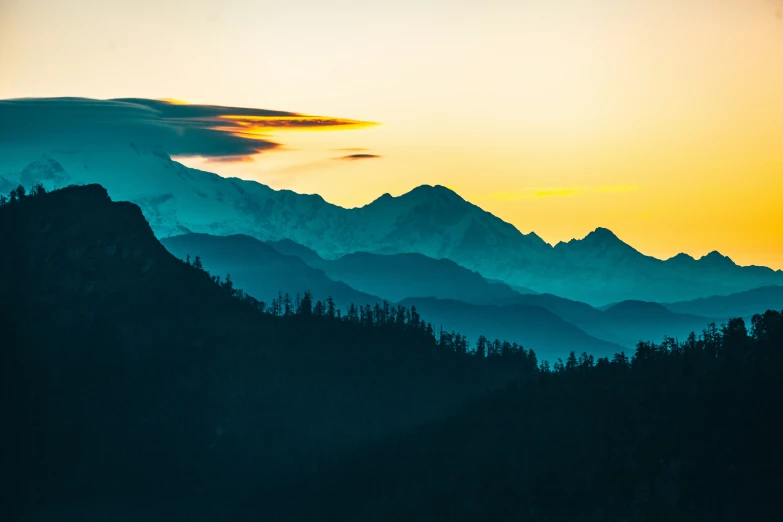 some clouds and mountains as the sun goes down