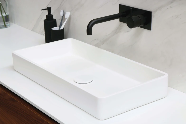 a white bathroom sink on top of a counter next to a faucet