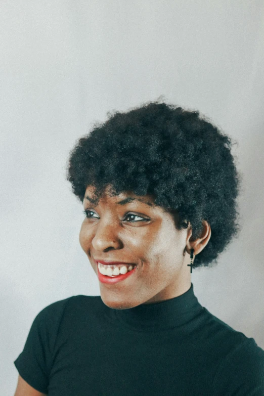 a close up of a woman wearing a black shirt and an afro hairstyle