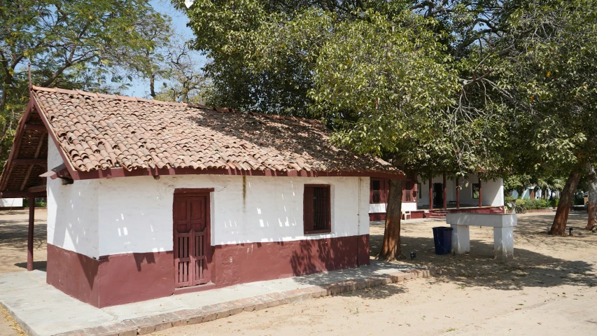 a small building has a roof that is red and white