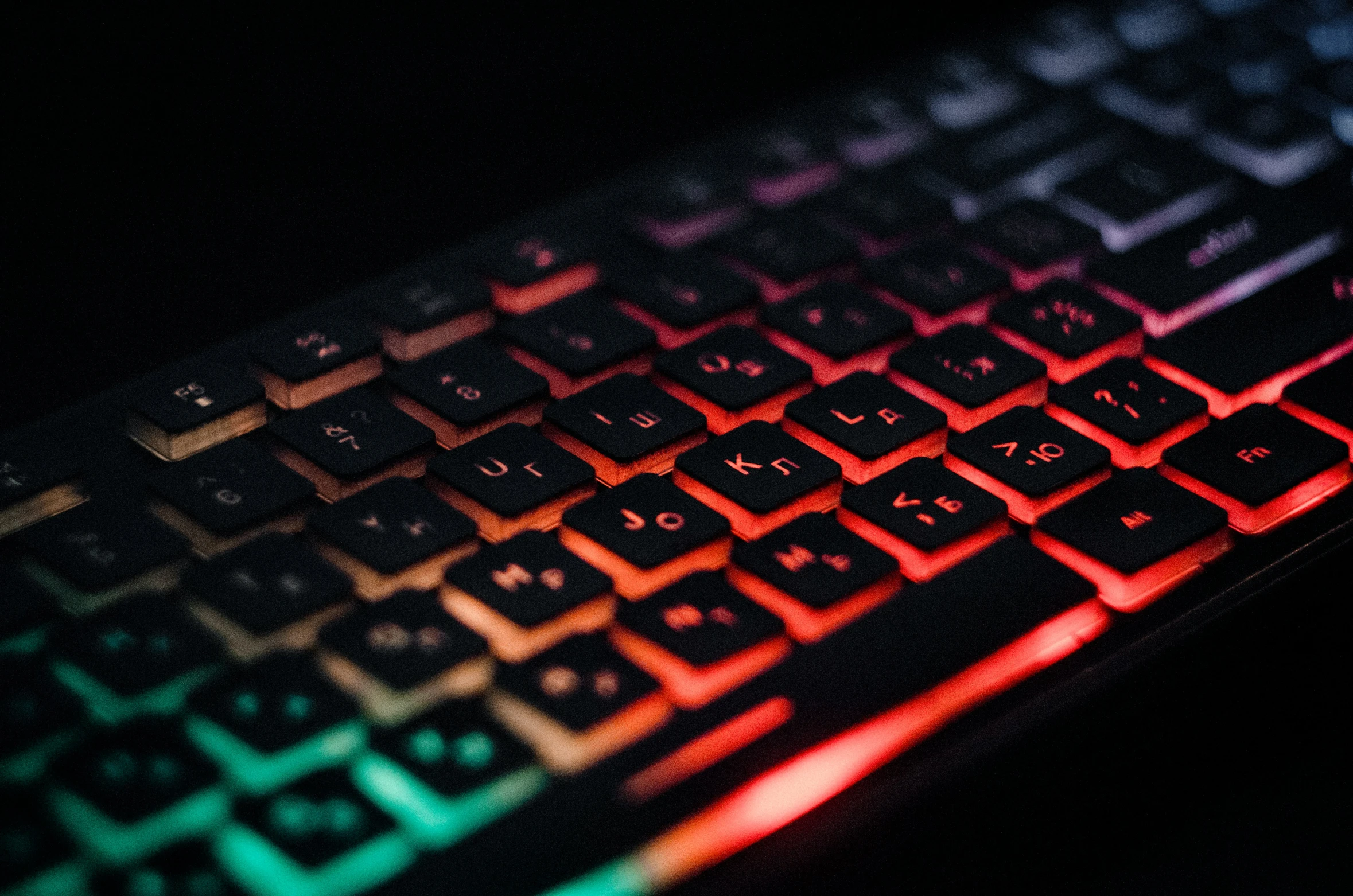 a computer keyboard lit up by the light from a bright red and green light