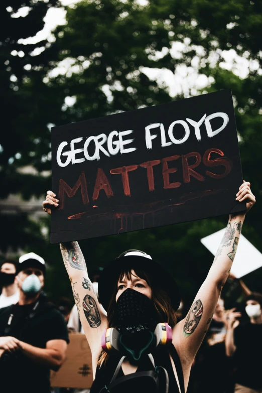 a person holding a sign that says george floyd matters