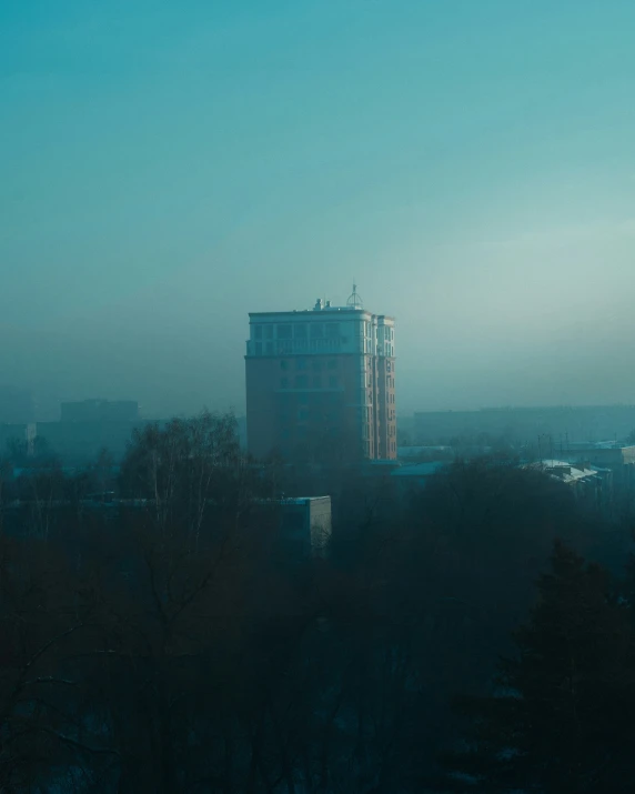 the cityscape has two large buildings and trees in front of it