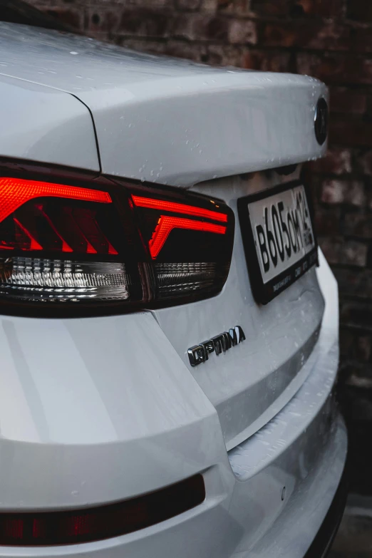 a white car with an orange light on its taillight