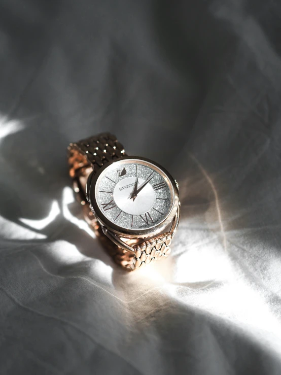 an elegant diamond watch on a silver fabric