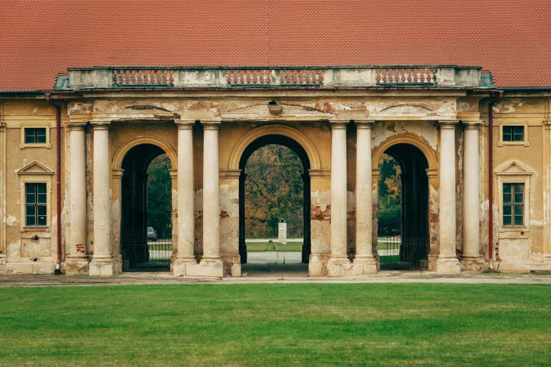 an old building with pillars and a red roof