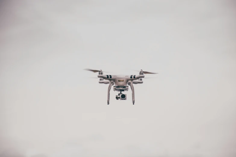a large grey and white dji - c60 is flying in the sky