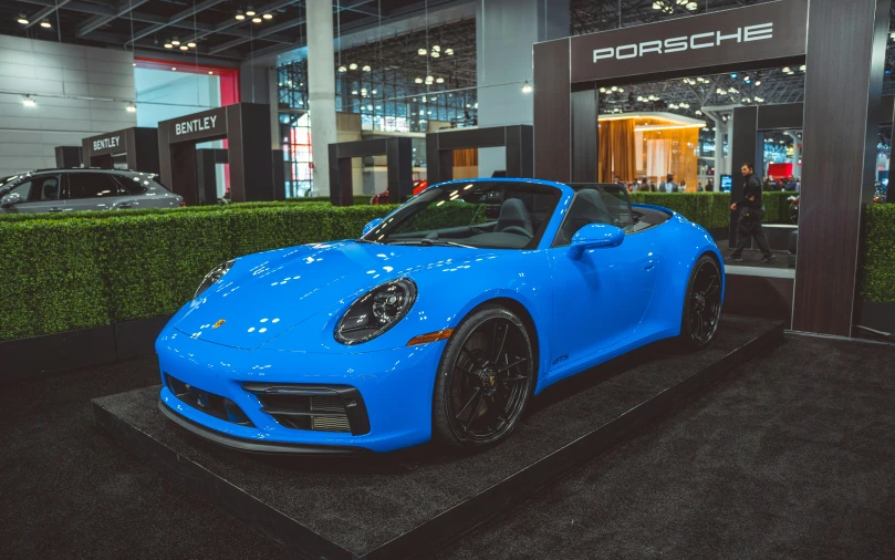 this blue porsche is on display at a show