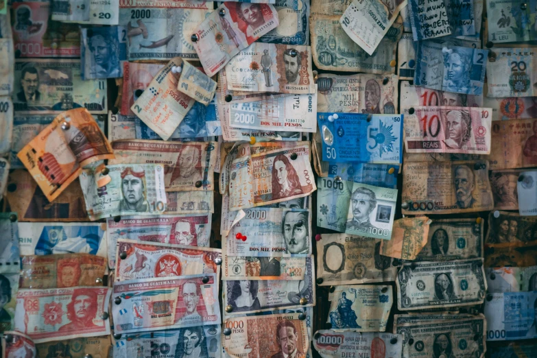 a bunch of different currency is hanging on the wall