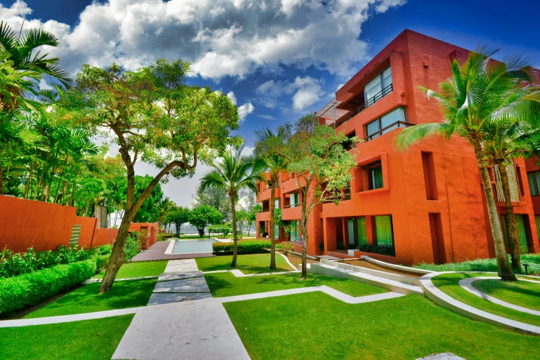 the orange building has a lot of trees and bushes